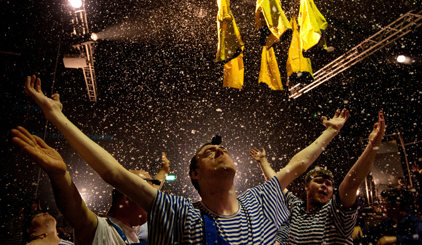 Men in stripey t shirts with their arms in the air